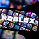 LONDON, UK - March 2021: Person holding a smartphone with Roblox game logo