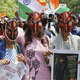 ゴキブリを模したお面をかぶった抗議集会の参加者＝2026年6月20日、インド・ニューデリー（共同）
