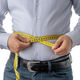お腹周りを巻き尺で測っている男性